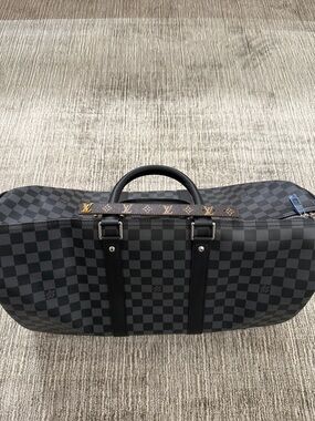 Black Damier Graphite Carryall Duffle with Monogram Accents and leather bracelet